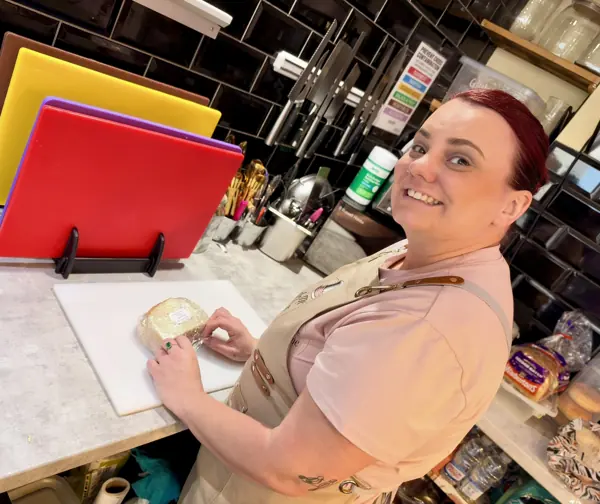 Preparing food behind the counter with colour-coded chopping boards